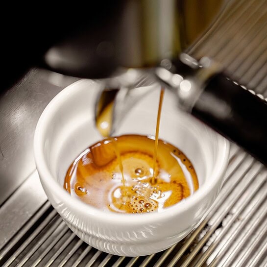 espresso z kávy Ebenica tekoucí z páky kávovaru