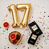 blend xvii na stole s konfetami, balónom v tvare čísla 17 a s ovocím